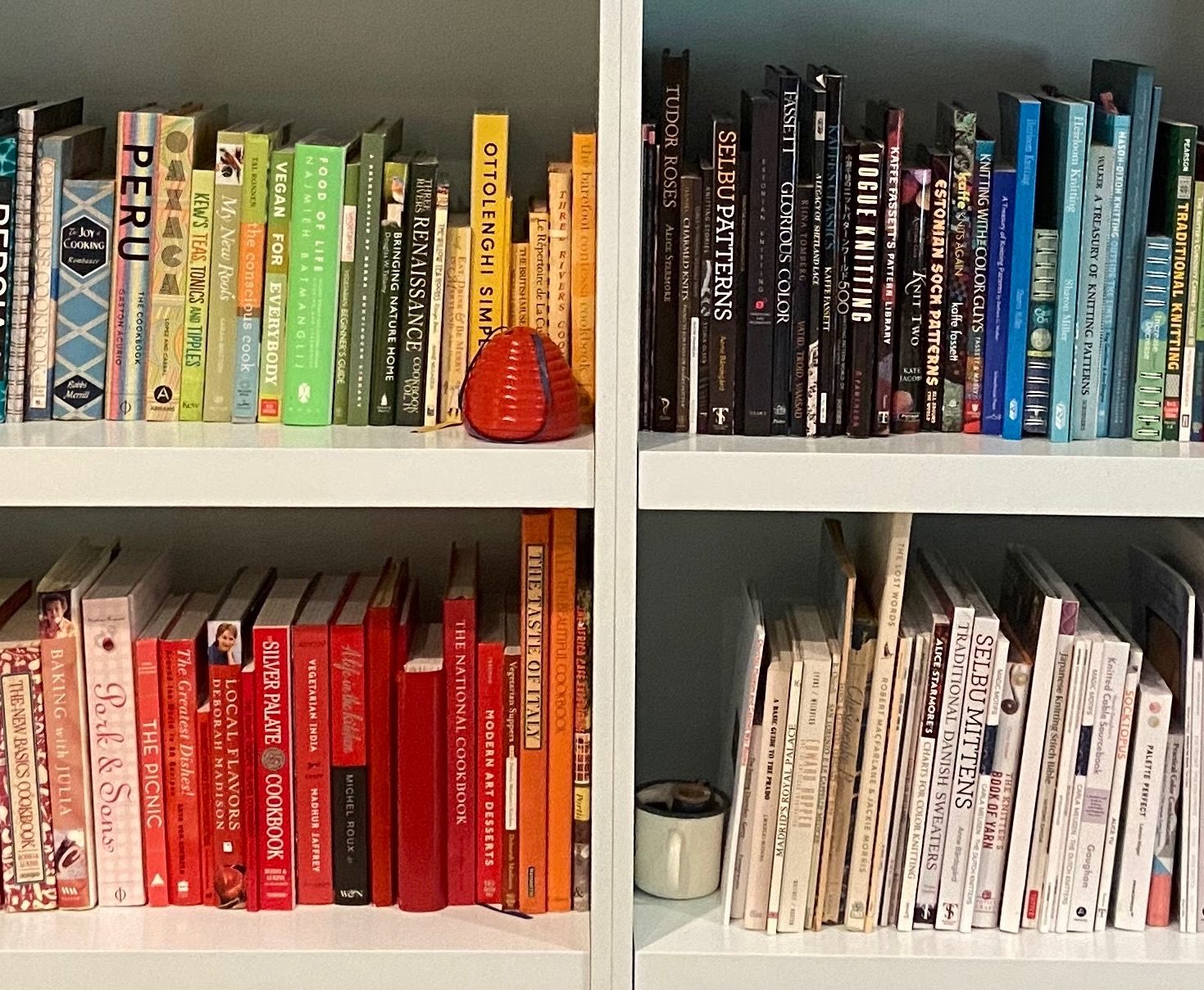 Bookshelves with cookbooks and knitting books arranged by color